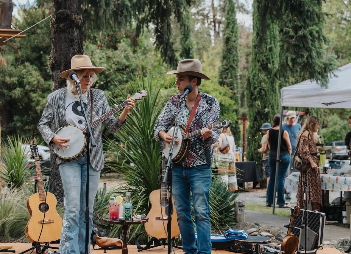 Live banjo musicians performing at the Applegate Evening Market