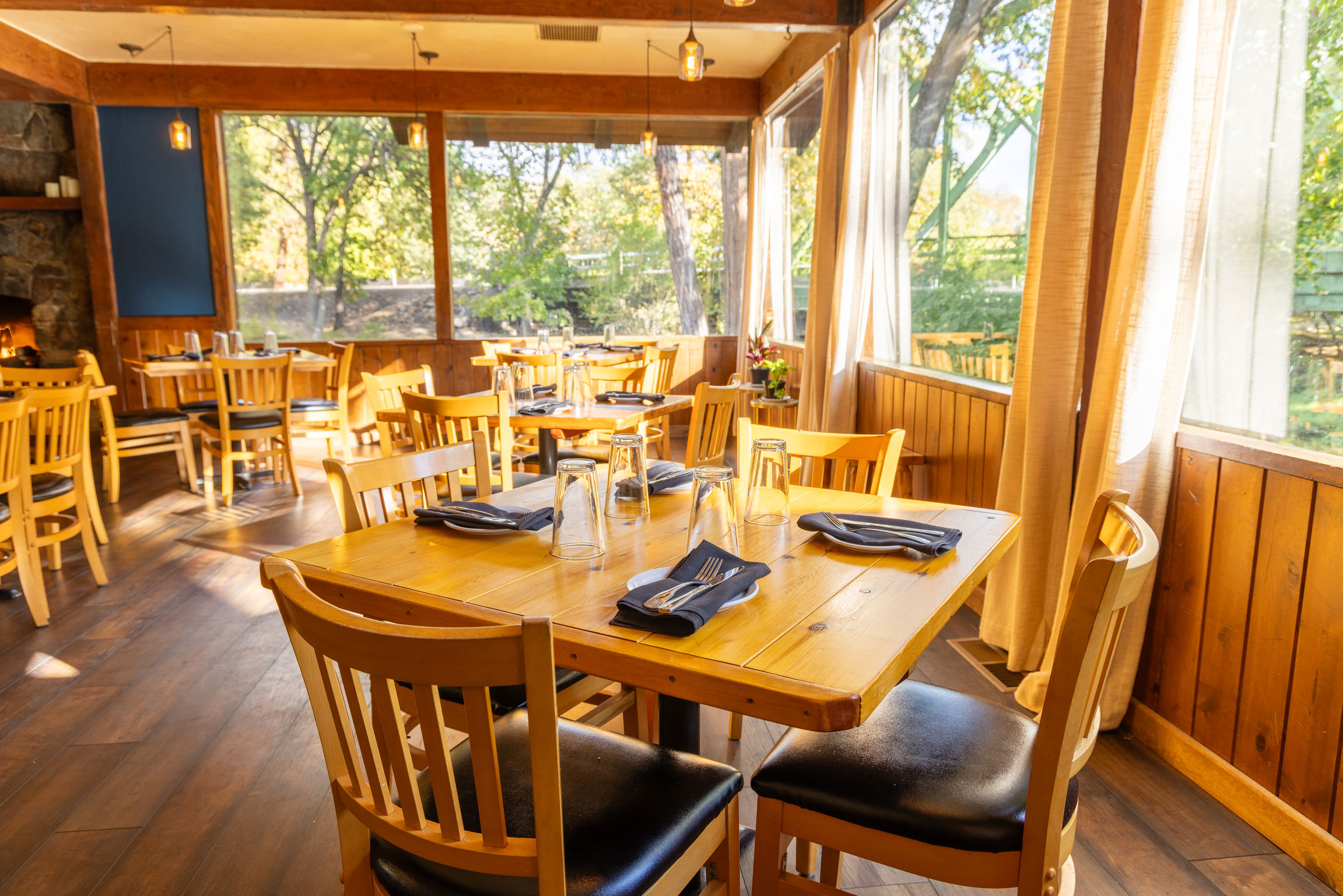 The sunlit dining room with river and forest views through the windows