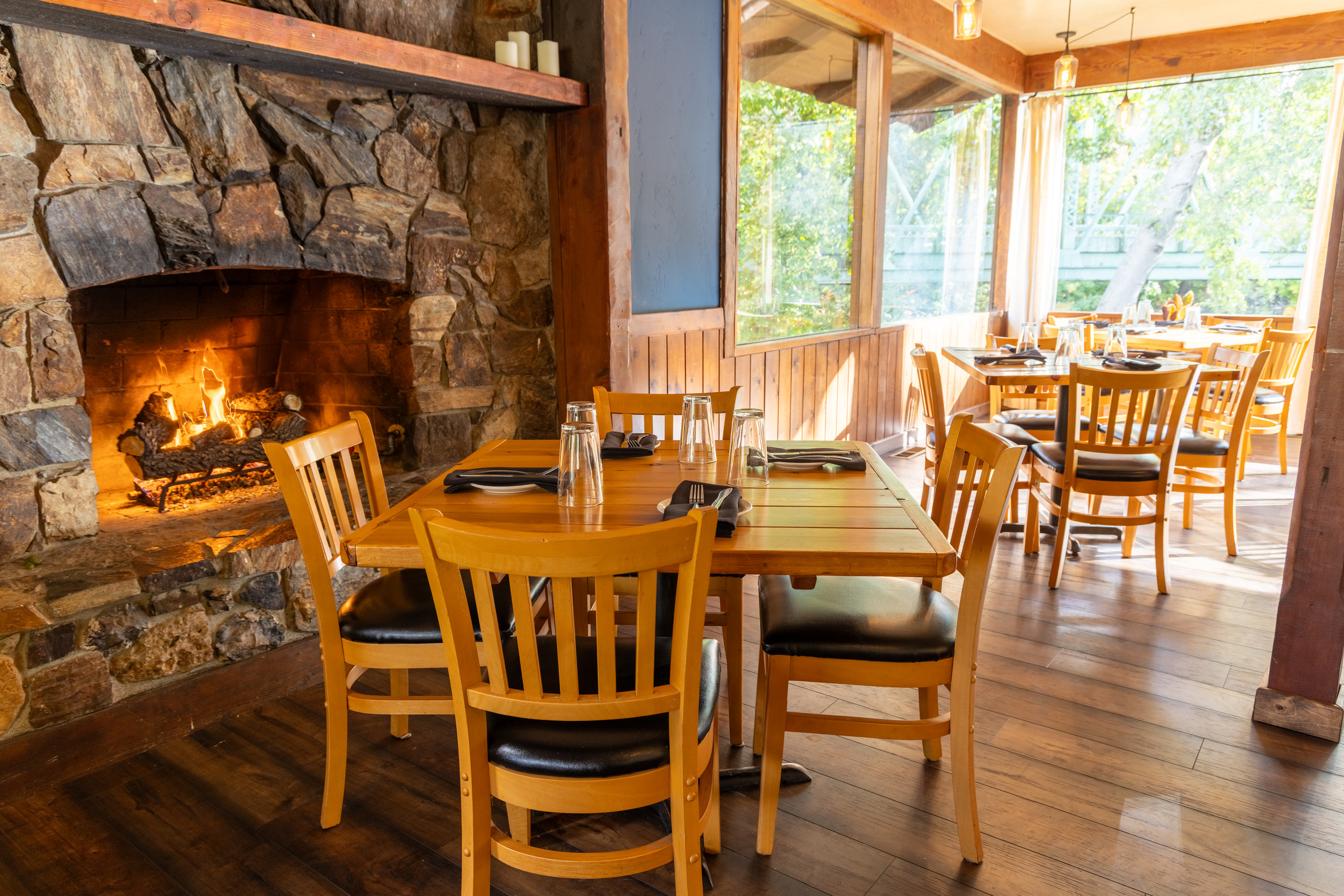 The fireside dining room at The Lindsay, with the stone hearth aglow